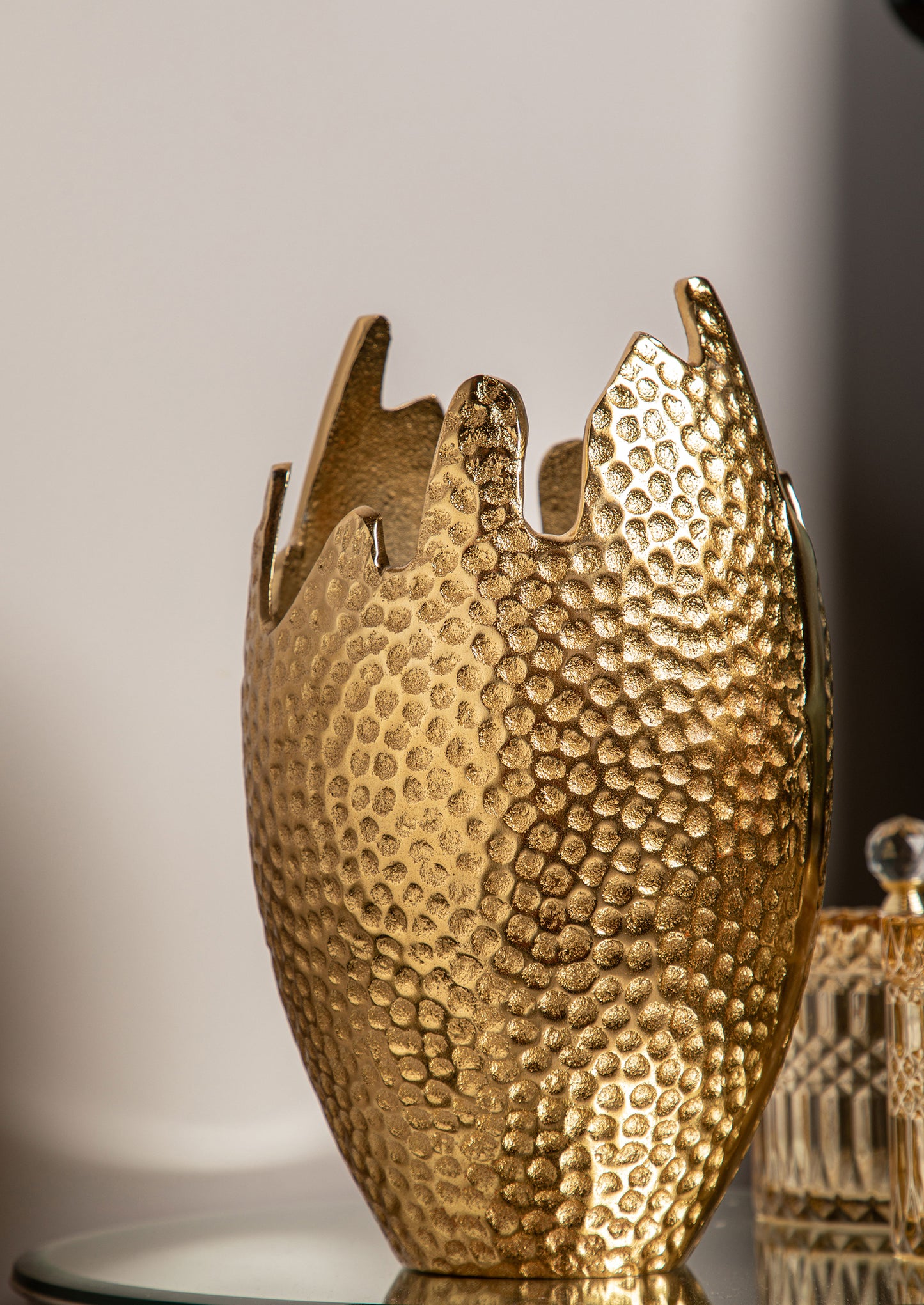 The Brass Dotted Vase boasts a modern design with tiny brass dots that add a unique and captivating texture.