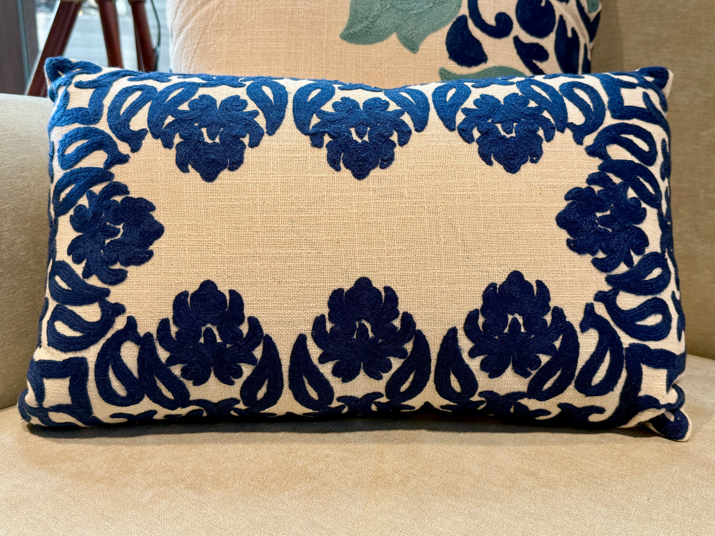 Featuring bold, hand-appliquéd floral and motif patterns in deep indigo on a natural beige cotton blend, its striking symmetry and rich texture add visual weight and elegance to beds, sofas, or accent chairs.