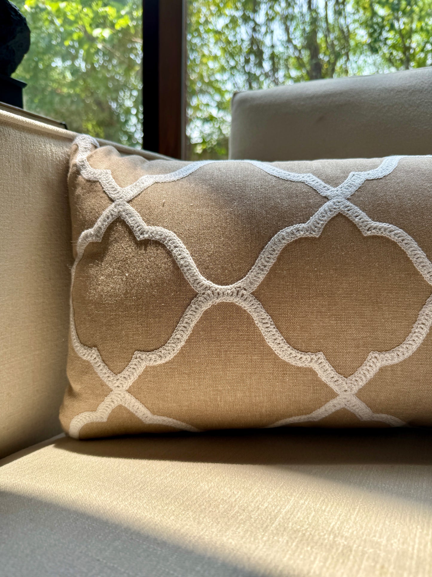 The Zahra Lattice Cushion features a classic Moroccan trellis pattern, delicately embroidered in ivory thread on a warm sand-toned base.