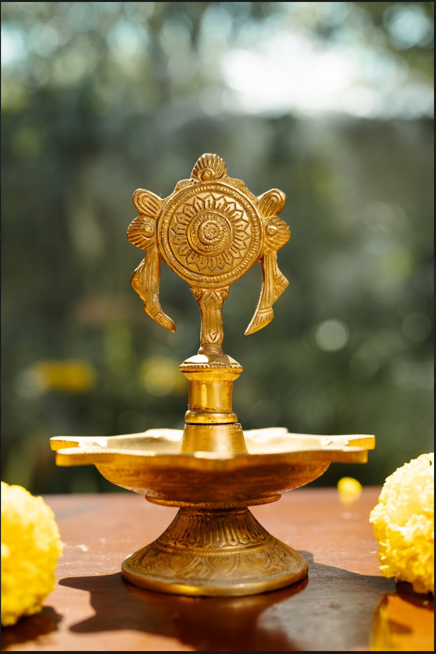 Expertly handcrafted, the diya features a detailed chakra (wheel) design, symbolizing the cycle of time, energy, and balance. Made from pure brass, this diya offers both aesthetic beauty and durability, making it perfect for pooja rituals, meditation spaces, or festive decor.