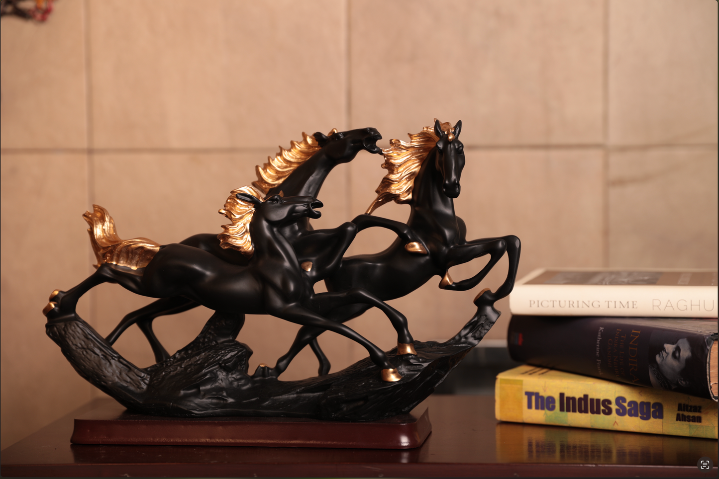 Crafted in premium resin and mounted on a rich wooden base, the matte black finish, paired with golden detailing on the manes and hooves, adds a touch of grandeur to this dynamic piece.