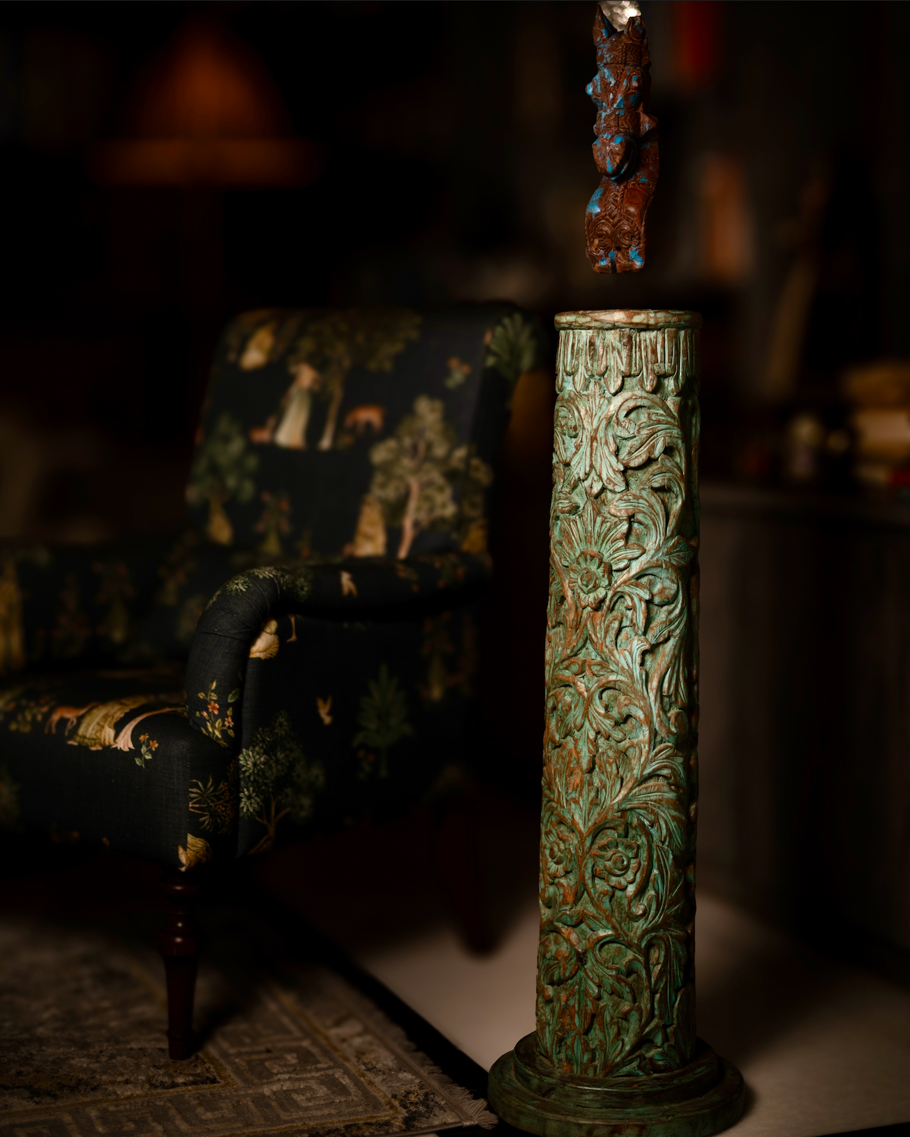 The Pushpa Stambh is a grand wooden pillar that carries the elegance of hand-carved floral motifs, flowing across its tall frame like a garden in bloom. Its natural greenish-blue patina, derived from plant-based pigments, enhances the depth of each carving while adding a soft vintage character.