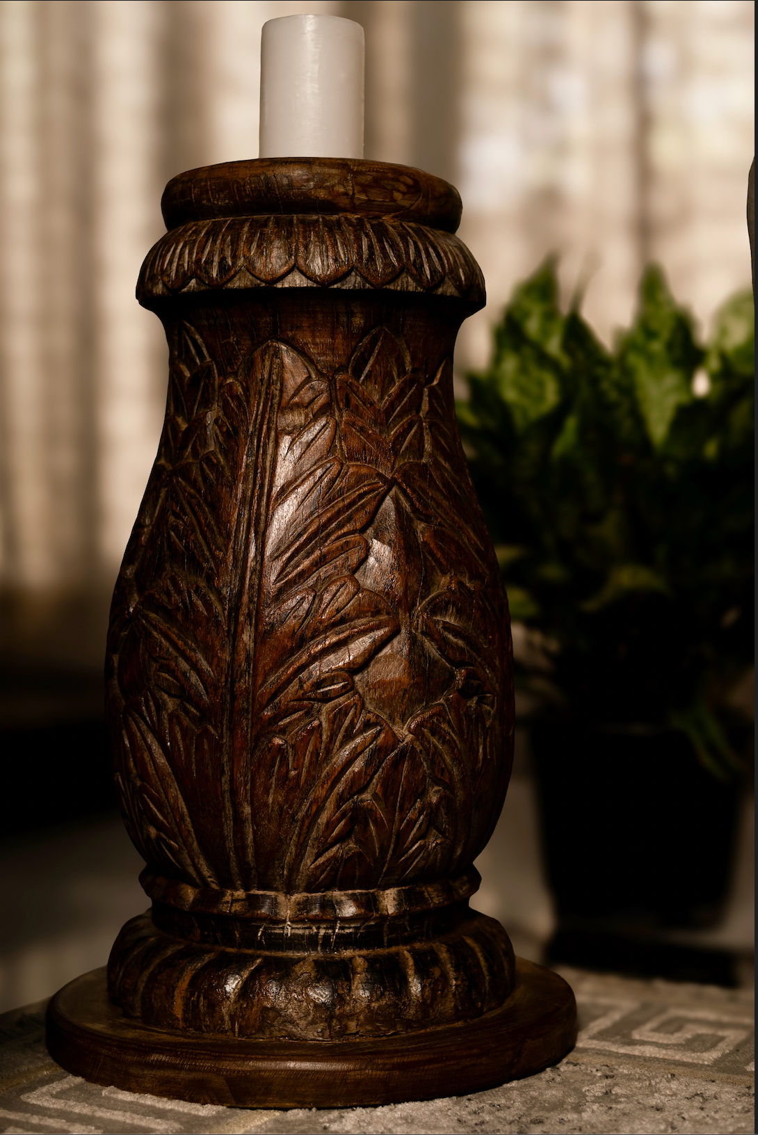 The Vanalata Stambh Candle Pillar is a celebration of nature carved into wood. Its rounded form is richly adorned with upward-flowing leaf motifs, evoking vines climbing toward light. Handcrafted from reclaimed solid wood.