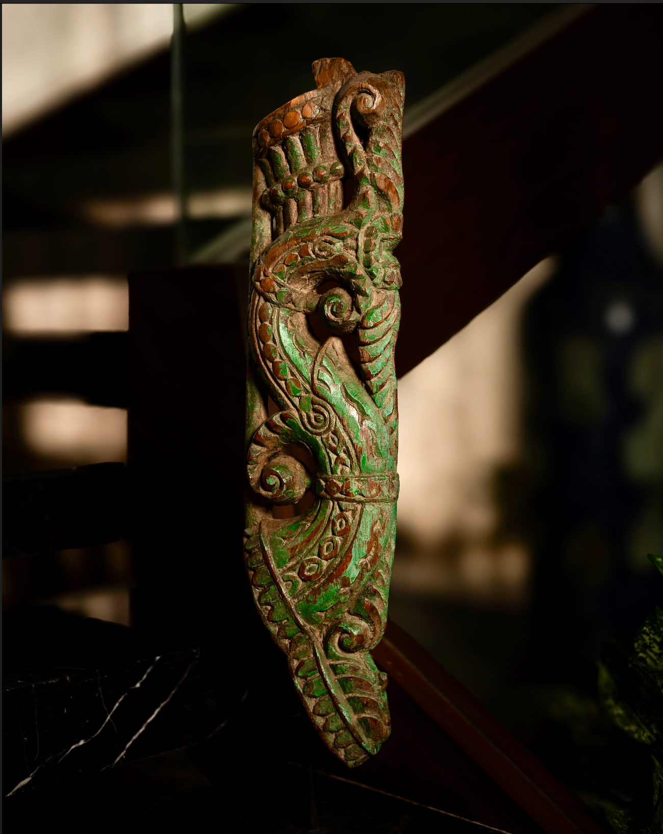 The Kritika brackets are salvaged fragments of heritage architecture, hand-carved from solid wood and finished with natural plant-based colors. Each piece is unique — Kritika I in deep green tones and Kritika II in earthy terracotta with teal accents