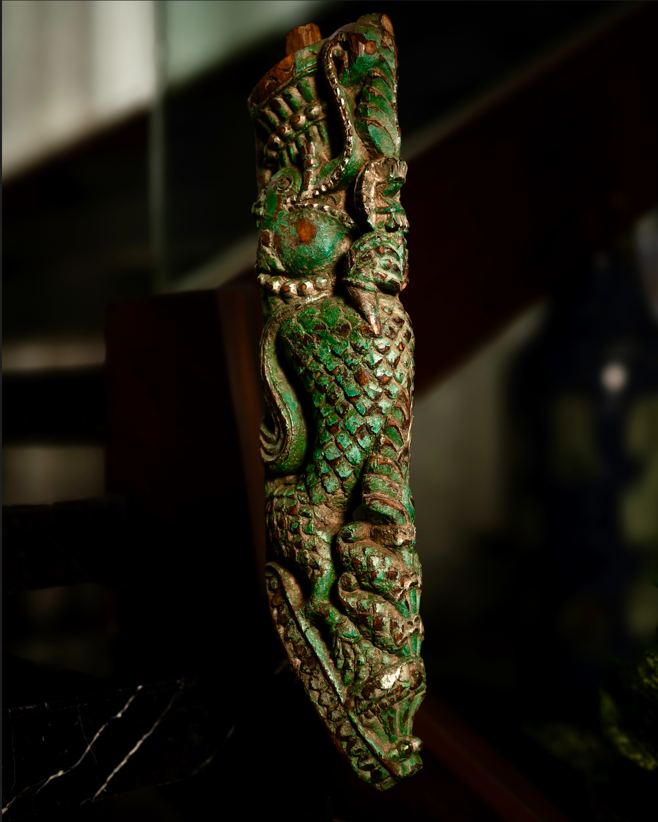 The Kritika brackets are salvaged fragments of heritage architecture, hand-carved from solid wood and finished with natural plant-based colors. Each piece is unique — Kritika I in deep green tones and Kritika II in earthy terracotta with teal accents