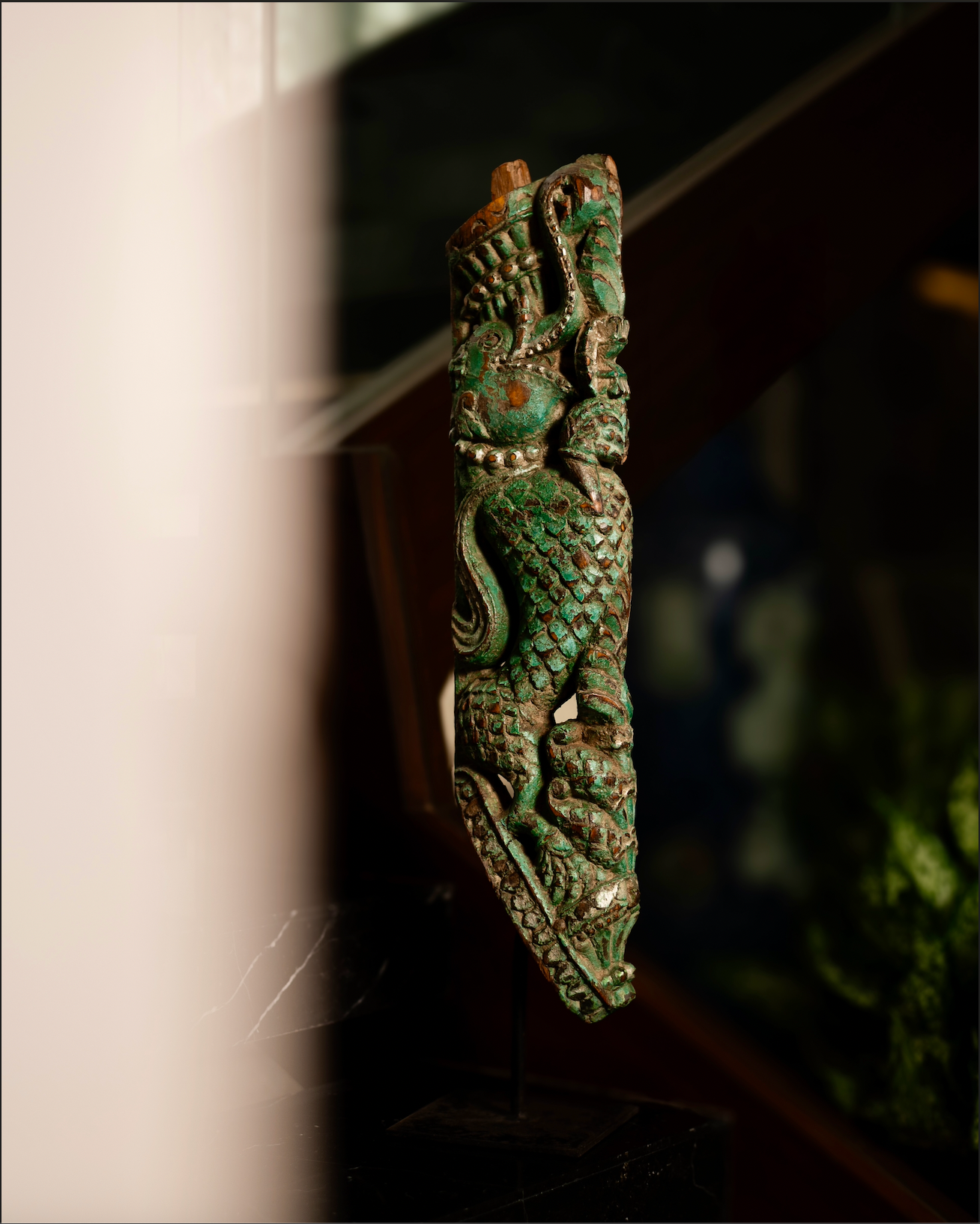 The Kritika brackets are salvaged fragments of heritage architecture, hand-carved from solid wood and finished with natural plant-based colors. Each piece is unique — Kritika I in deep green tones and Kritika II in earthy terracotta with teal accents