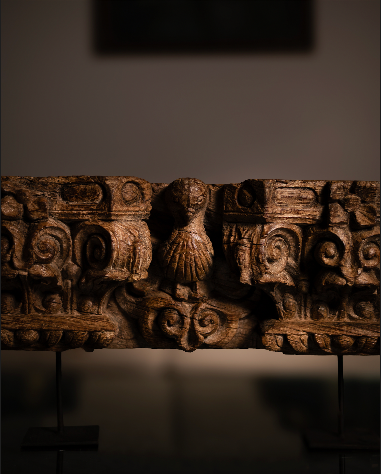 The Garuda Shilp is a remarkable salvaged fragment of heritage architecture, hand-carved from solid wood. With ornate scrollwork and a central bird motif reminiscent of Garuda, it reflects the grandeur and symbolism of temple and haveli design.