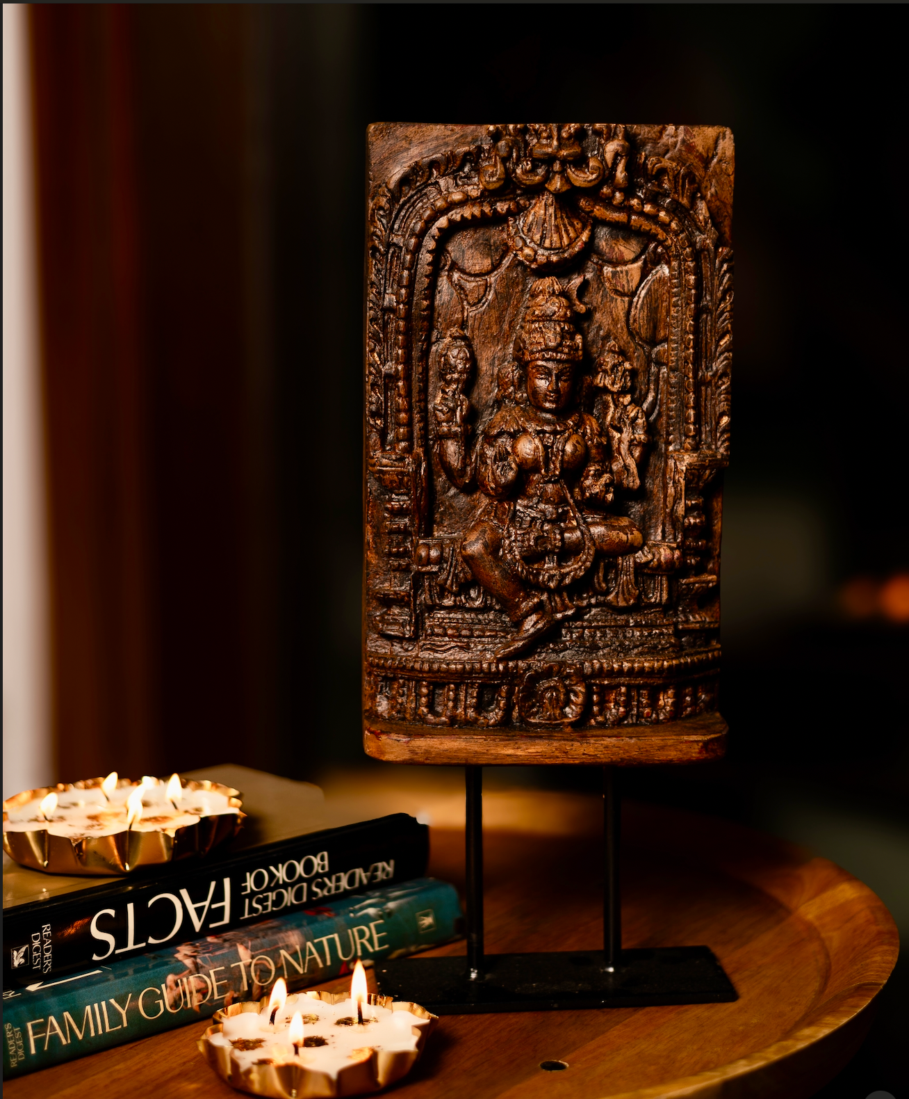 The Devālay Shilp Wooden Temple Panel carries the grace of sacred Indian artistry. Hand-carved from reclaimed wood, it depicts a richly detailed, the deity Laxmi, framed within ornate temple arches.