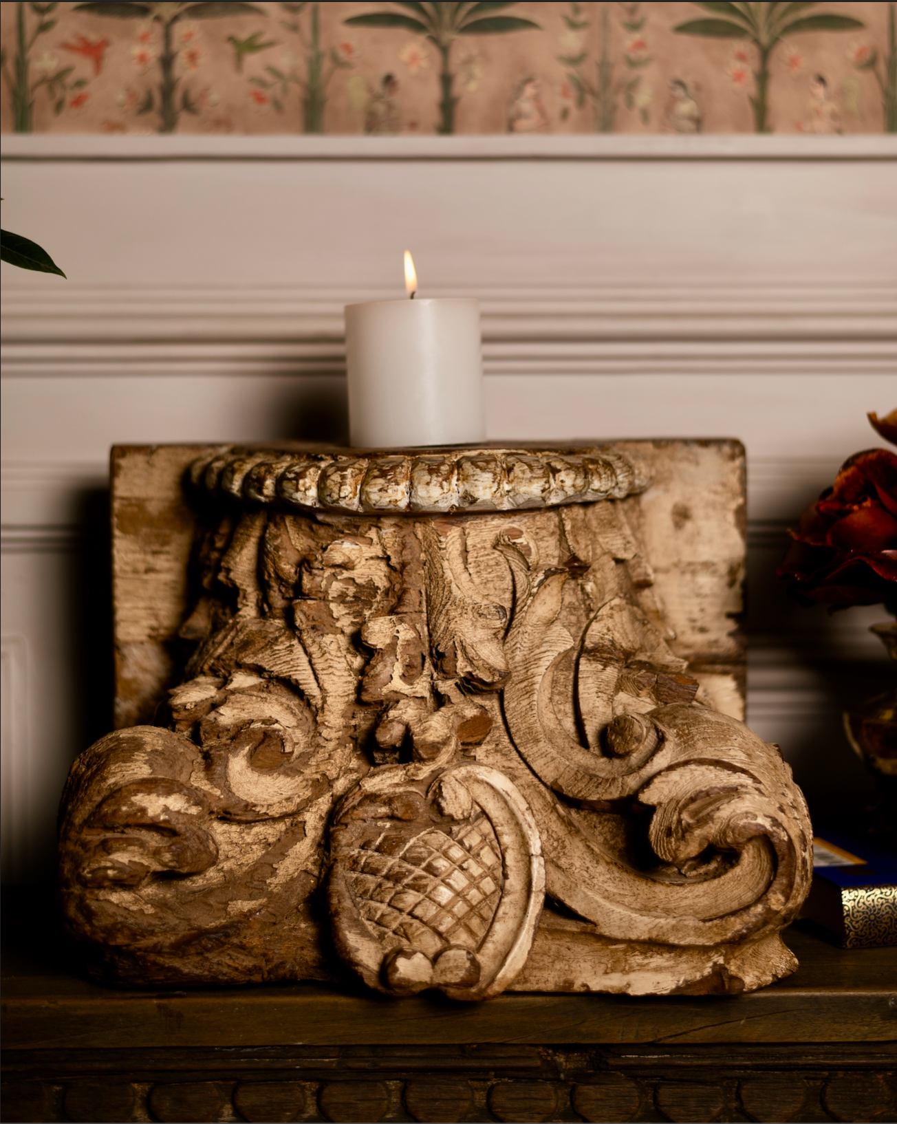 The Kusum Stambh Candle Pedestal is a stunning fragment of architectural heritage, hand-carved from solid reclaimed wood. With its ornate scrolls, floral accents, and natural distressed finish
