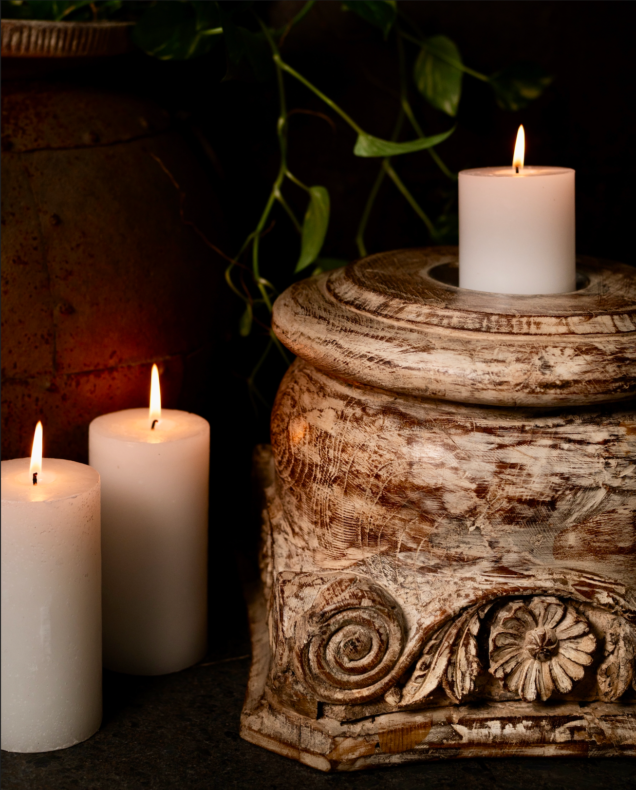 The Akriti Stambh Candle Pedestal, its detailed scrolls and pillar-inspired silhouette give it a timeless architectural charm, while the raw, unfinished surface highlights the natural character of the wood