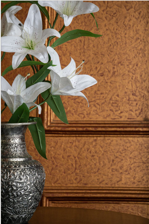 An array of flowers is featured on its body, beaten into metal, finished with a lacquer polish. The vase also features a bird on its side, as to show its attraction to the flowers.