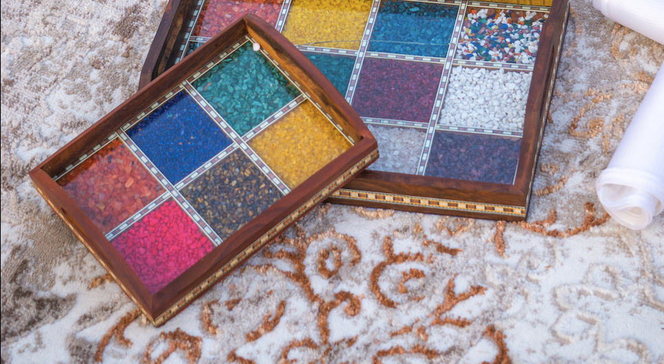 A Wooden Tray with a inlay of various gemstones to give it a colourful and unique appeal, with a glass & wooden frame covering the gemstones.