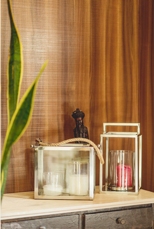 A pair of stainless steel lanterns with one being rectangular & one being cylindrical in shape, both adorning a handle for increased convenience .