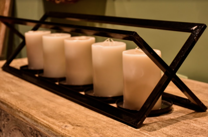 A Modern, beautiful candle stand, with an 'X' structure, made of Metal, with provisions given for 5 (five) Candle Holders, in a glossy black finish.