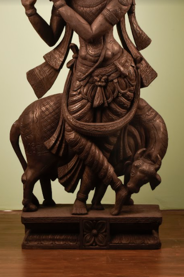 A Wooden Krishna Statue, made of mango wood, hand carved into lord krishna playing his flute.