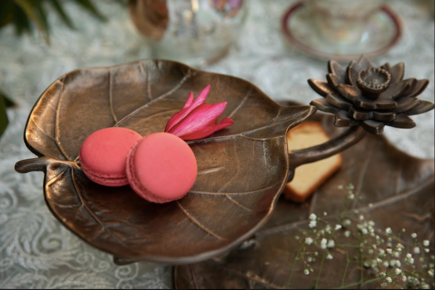 A 2-Tier, Rustic Metallic Food Stand In The Image Of A Petal With A Pencil Candle Holder.