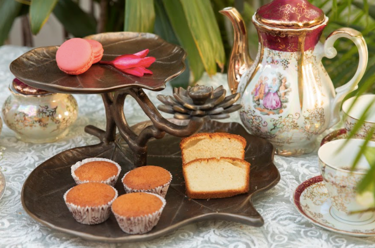 A 2-Tier, Rustic Metallic Food Stand In The Image Of A Petal With A Pencil Candle Holder.