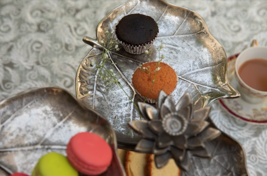 A 3-Tier, Rustic Metallic Food Stand In The Image Of A Petal With A Pencil Candle Holder.