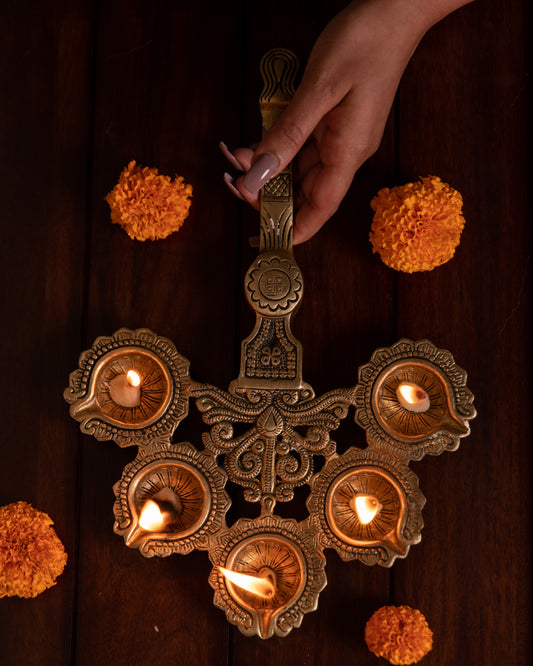 Brass Aarti Diya is meticulously designed by skilled artisans using pure brass, the five wicks of this diya represent the five elements of earth, water, fire, air, and ether.