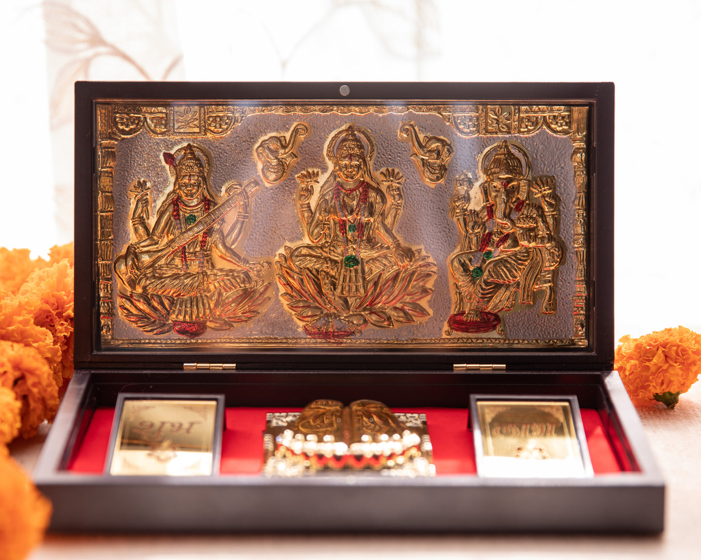 LeelaTheStore’s divine 24K Laxmi, Ganesh, and Saraswati Pooja Box, the 3 idols have been engraved onto the top half of the box and have been finely wrapped in gold foil.