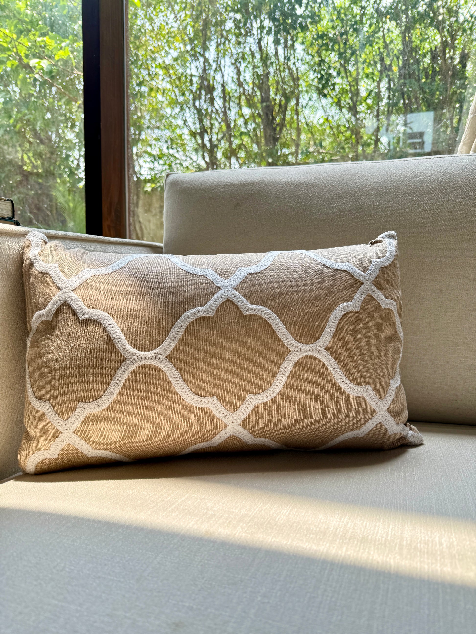 The Zahra Lattice Cushion features a classic Moroccan trellis pattern, delicately embroidered in ivory thread on a warm sand-toned base. 