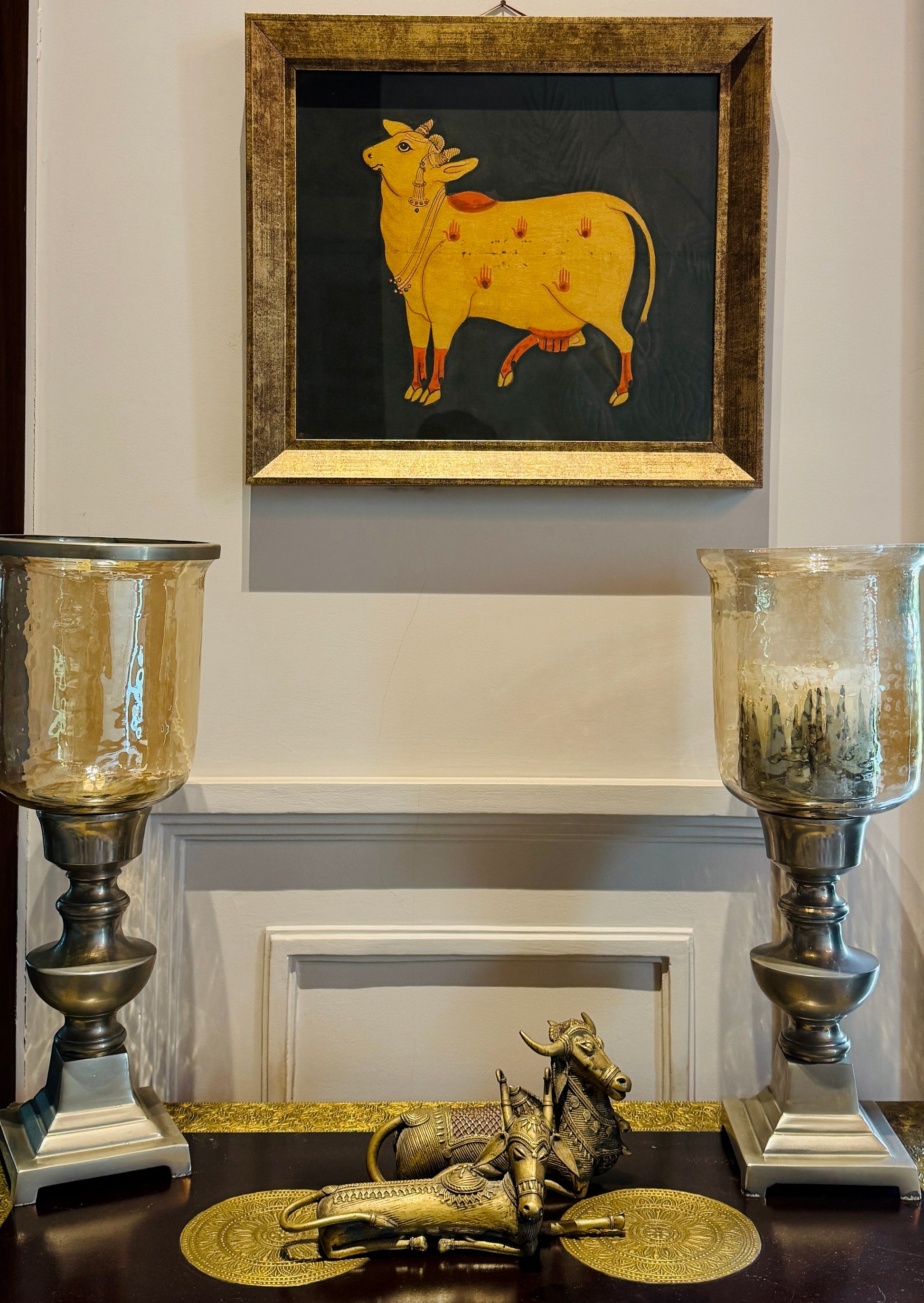 Hand-painted with real gold | Framed | Origin: Udaipur, Rajasthan This Udaipuri Pichvai captures Kamadhenu — the divine cow believed to grant all desires. Painted using natural pigments and real gold detailing, the artwork reflects the sacred richness of traditional temple murals. 