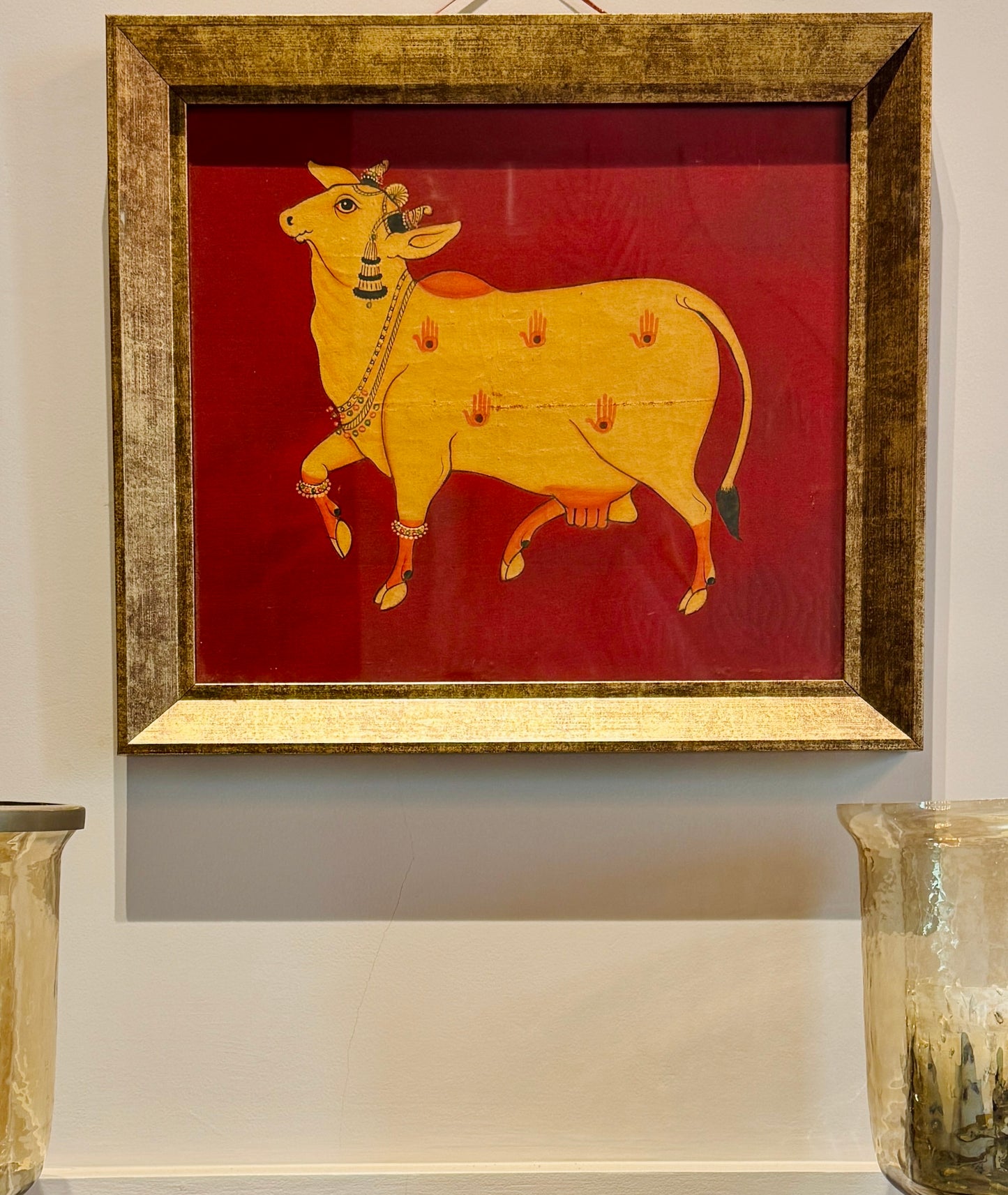 Hand-painted with real gold | Framed | Origin: Udaipur, Rajasthan This Udaipuri Pichvai captures Kamadhenu — the divine cow believed to grant all desires. Painted using natural pigments and real gold detailing, the artwork reflects the sacred richness of traditional temple murals. 