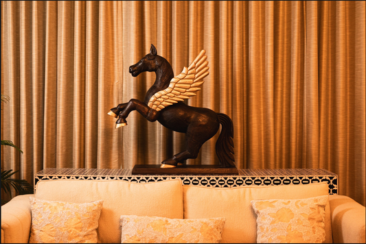 Channel the mythical charm of Pegasus into your home decor with this finely carved wooden sculpture. Expertly hand-painted, the majestic creature’s bold brown form is accentuated by elegant golden wings and hooves, creating a stunning contrast. 