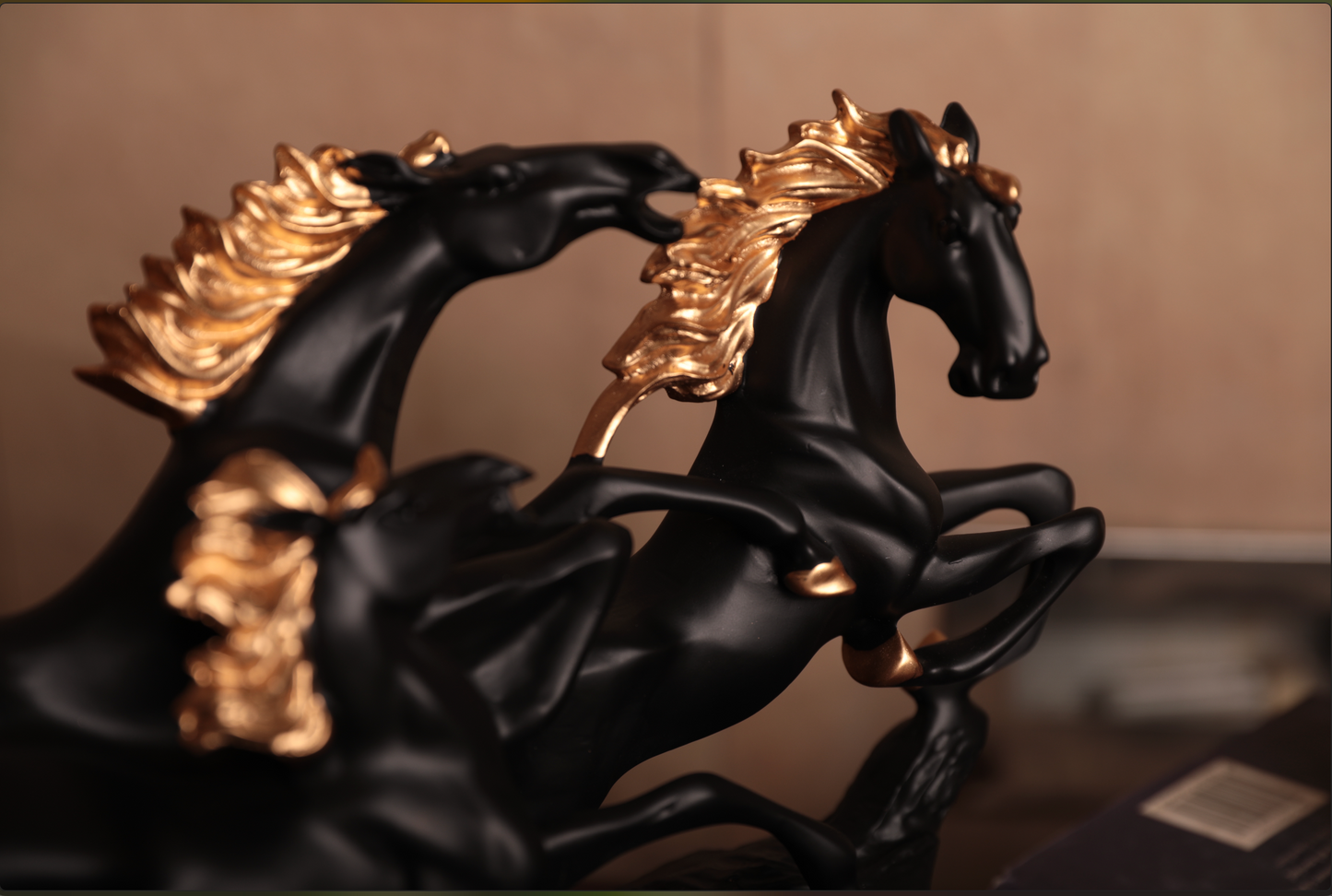 Crafted in premium resin and mounted on a rich wooden base, the matte black finish, paired with golden detailing on the manes and hooves, adds a touch of grandeur to this dynamic piece. 