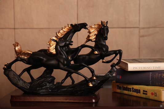 Crafted in premium resin and mounted on a rich wooden base, the matte black finish, paired with golden detailing on the manes and hooves, adds a touch of grandeur to this dynamic piece. 