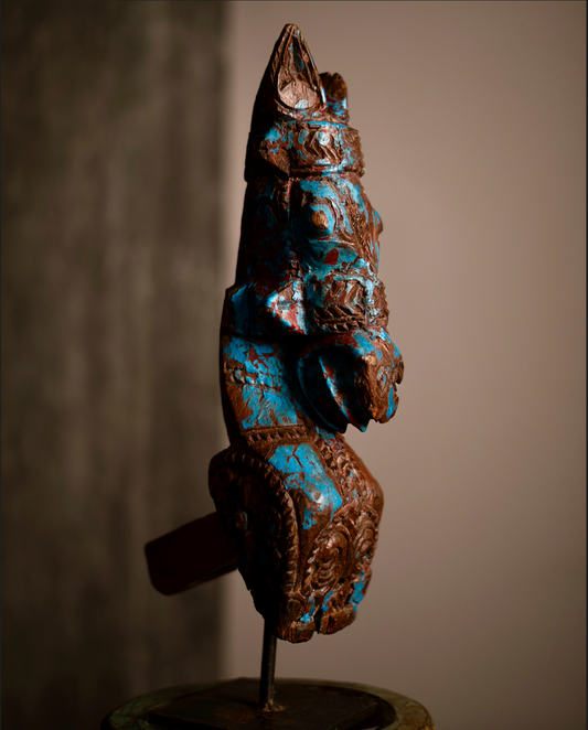 The Neelashva is a hand-carved wooden horse head sculpture, brought to life with a rare plant-based turquoise blue patina. Once part of an architectural fragment, its bold lines and ornate detailing reflect strength, vitality, and auspicious symbolism. 