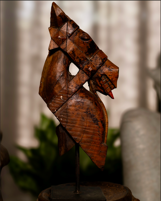 The Ashva Shilp is a hand-carved wooden horse head sculpture that embodies strength and vitality. With its natural orange patina and the striking detail of a pink-painted tongue, this salvaged fragment carries both character and charm. 