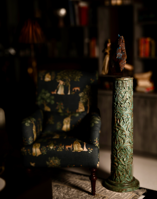 The Pushpa Stambh is a grand wooden pillar that carries the elegance of hand-carved floral motifs, flowing across its tall frame like a garden in bloom. Its natural greenish-blue patina, derived from plant-based pigments, enhances the depth of each carving while adding a soft vintage character. 