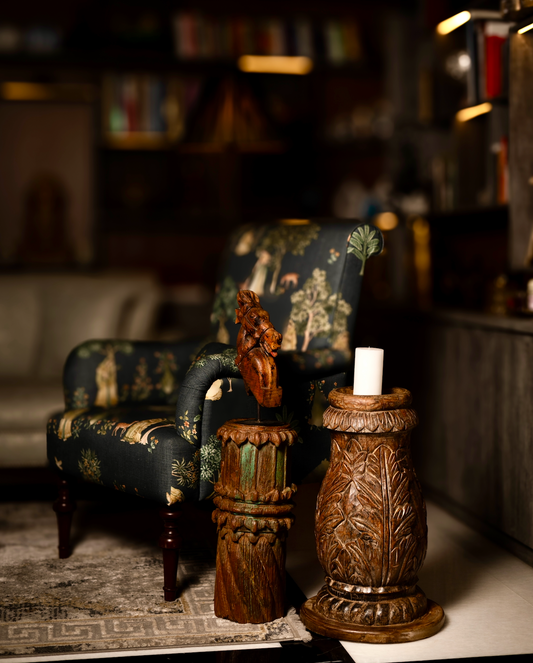The Vanalata Stambh Candle Pillar is a celebration of nature carved into wood. Its rounded form is richly adorned with upward-flowing leaf motifs, evoking vines climbing toward light. Handcrafted from reclaimed solid wood.