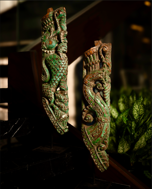 The Kritika brackets are salvaged fragments of heritage architecture, hand-carved from solid wood and finished with natural plant-based colors. Each piece is unique — Kritika I in deep green tones and Kritika II in earthy terracotta with teal accents 