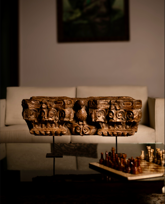 The Garuda Shilp is a remarkable salvaged fragment of heritage architecture, hand-carved from solid wood. With ornate scrollwork and a central bird motif reminiscent of Garuda, it reflects the grandeur and symbolism of temple and haveli design. 