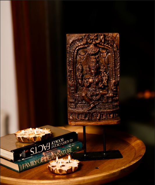 The Devālay Shilp Wooden Temple Panel carries the grace of sacred Indian artistry. Hand-carved from reclaimed wood, it depicts a richly detailed, the deity Laxmi, framed within ornate temple arches. 