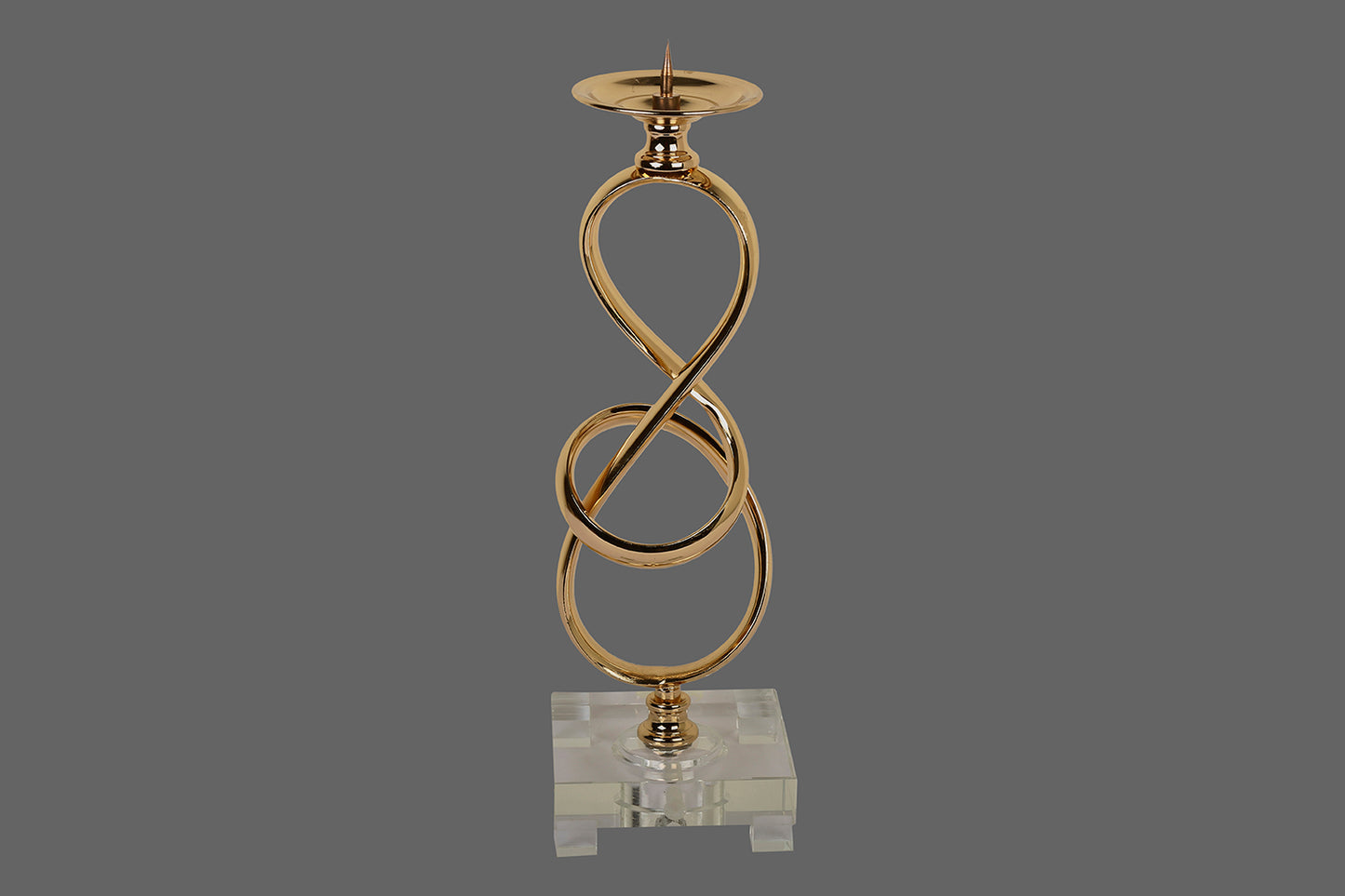 A Metallic Candle stand, with a chrome gold finish and in shape of a knot.