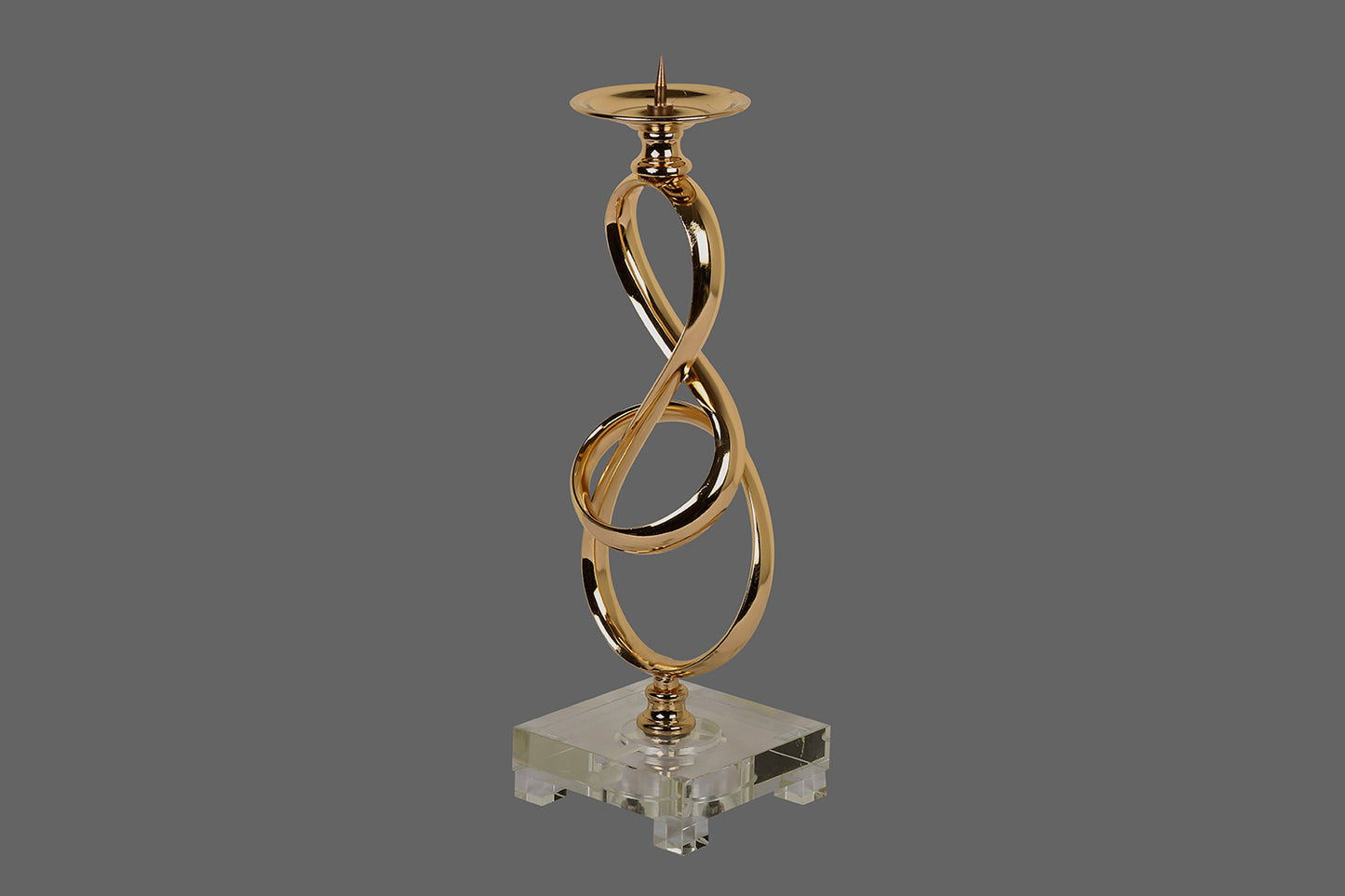 A Metallic Candle stand, with a chrome gold finish and in shape of a knot.