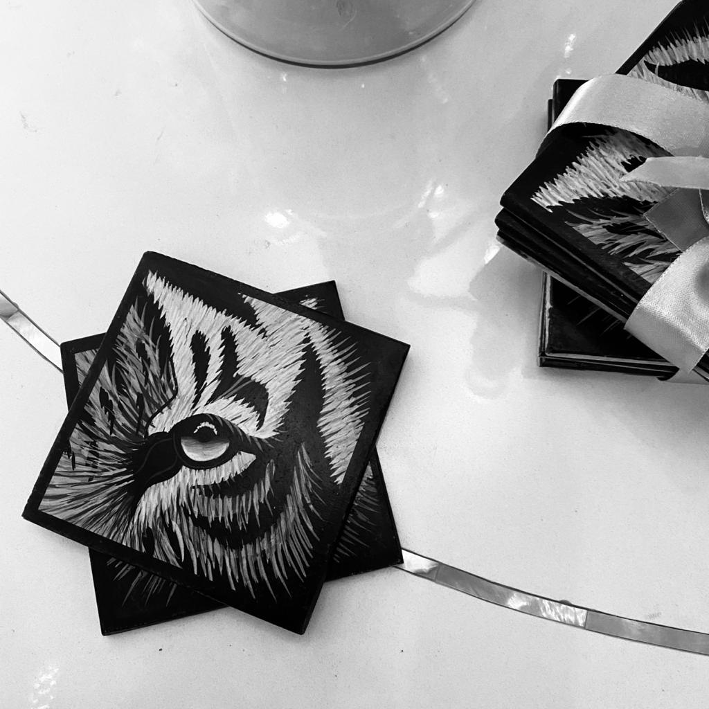 A Marble Coaster Set of 4, with handpainted detail of the close up of a tiger's eye, in black & White. 