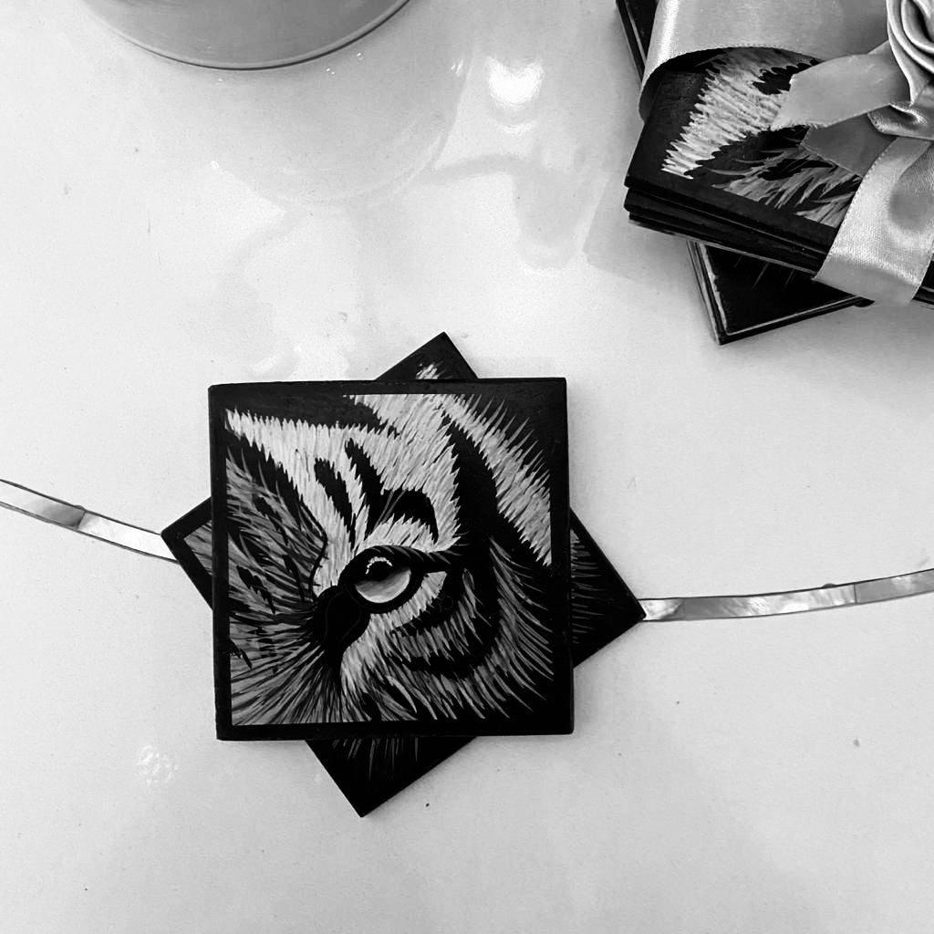 A Marble Coaster Set of 4, with handpainted detail of the close up of a tiger's eye, in black & White. 