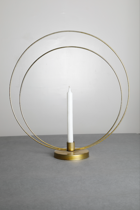 A gold Loop Candle Stand with gold coating and a candle holder in the centre