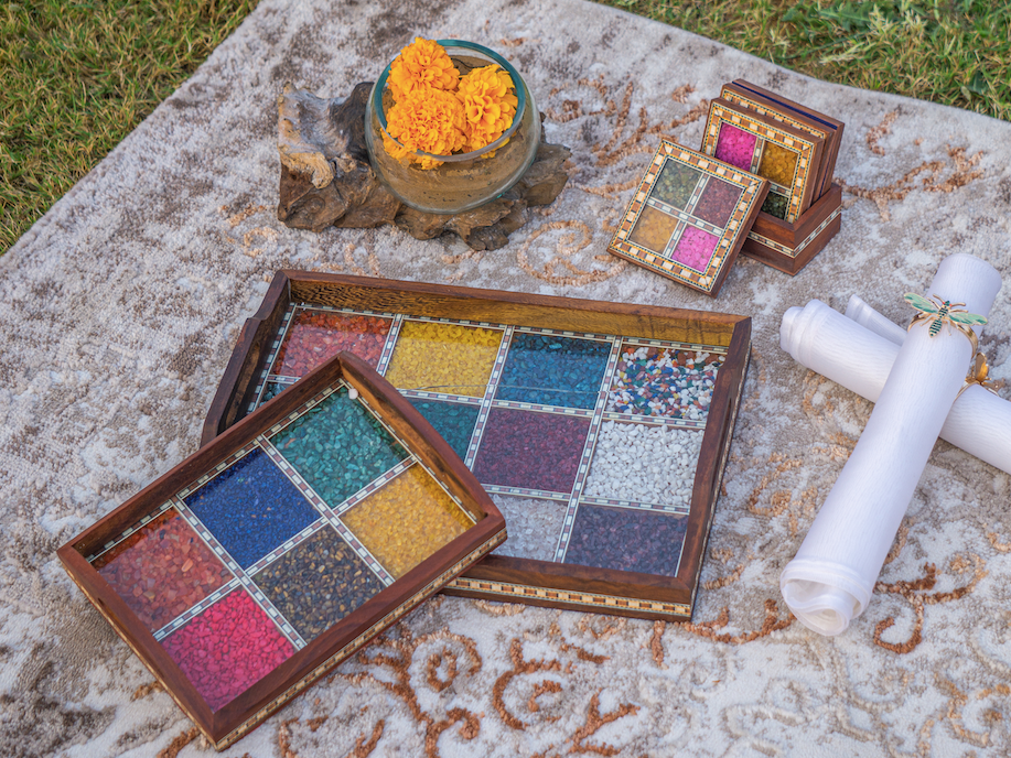 A Wooden Tray with a inlay of various gemstones to give it a colourful and unique appeal, with a glass & wooden frame covering the gemstones.