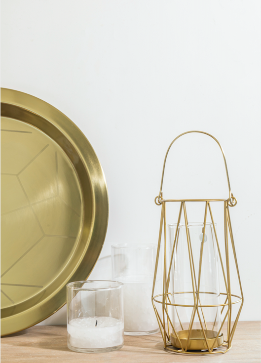  A metal Candle stand with a gold finish with a cylindrical glass candle holder given within