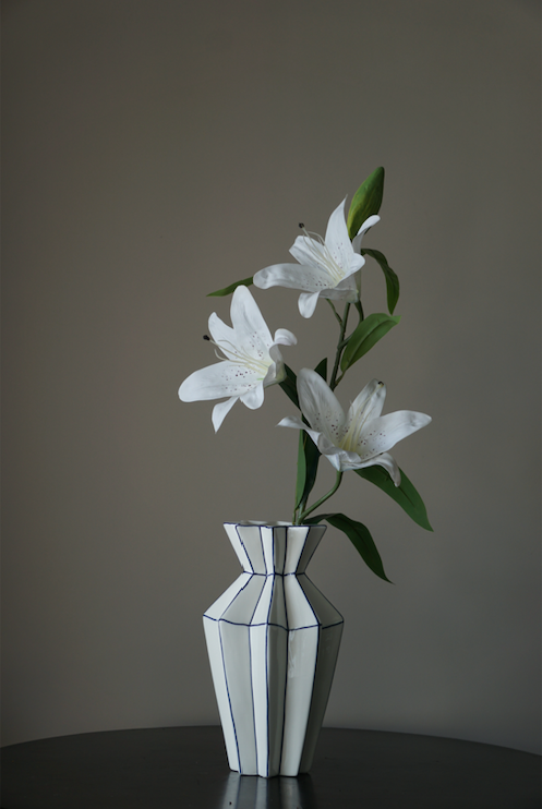 A symmetrically pleasing white porcelain flower vase with precise symmetrical corners highlighted in Royal Blue.