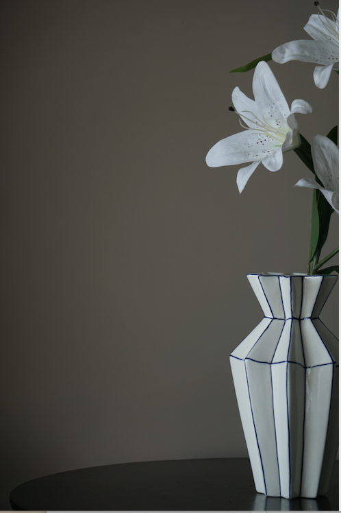 A symmetrically pleasing white porcelain flower vase with precise symmetrical corners highlighted in Royal Blue.