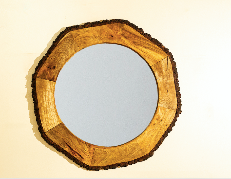 A round wooden mirror with a rustic appeal.