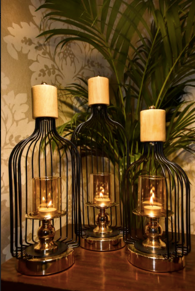A Set of 3, are made of metal, in a glossy black finish supported by a metal base underneath, that comes in a chrome gold finish. The Murk Metal Lanterns are partially open on one end to keep your choice of candles within the glass candle holder that is supported by another metal stand within, on which it is mounted upon.