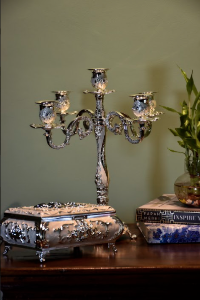 A Silver Candle Stand Made With Metal Paired With White Accents