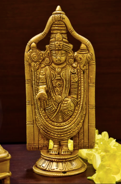 A brass tirupathi idol with intricate hand made carvings on a brass canvas.